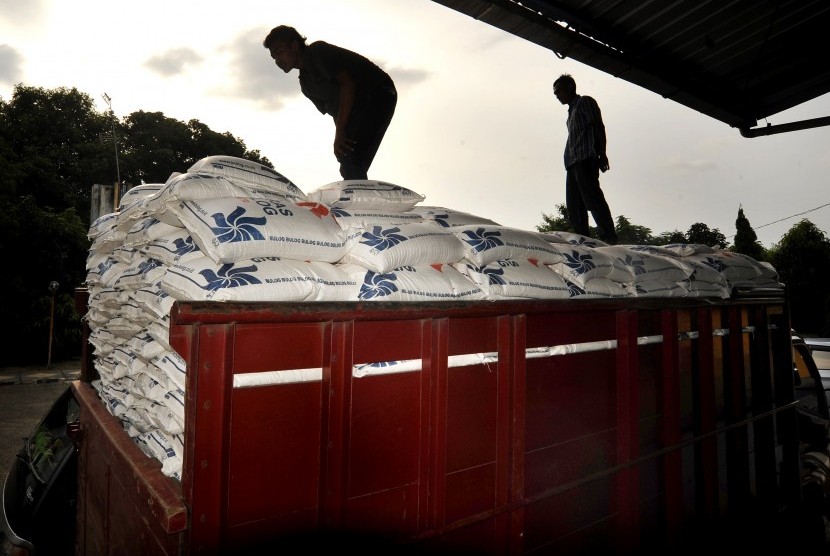 Pekerja memeriksa beras miskin (raskin) di bak truk di area gudang Bulog Divre Serang, Banten, Jumat (22/4).