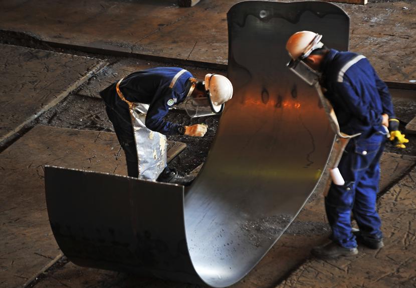 Pekerja memeriksa kualitas lempengan baja panas di pabrik pembuatan hot rolled coil (HRC) PT Krakatau Steel (Persero) Tbk di Cilegon, Banten.