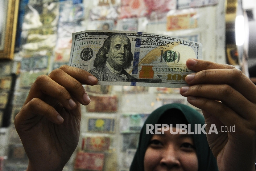 Pekerja memeriksa mata uang dolar di Jakarta, Selasa (13/9).