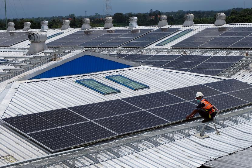 Pekerja memeriksa panel-panel surya dari Pembangkit Listrik Tenaga Surya (PLTS) di atap pabrik di Badung, Bali, Rabu (31/8/2022). 