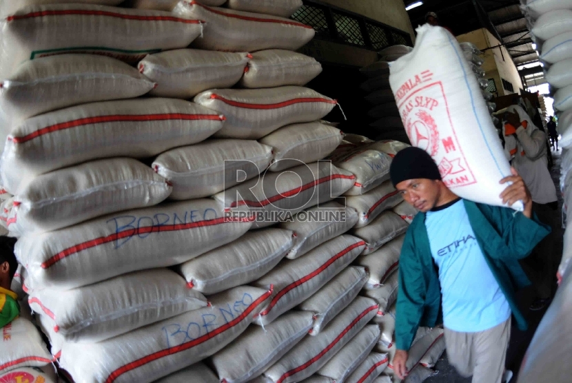  Pekerja memikul karung beras di Pasar Induk Cipinang, Jakarta, Kamis (15/10).