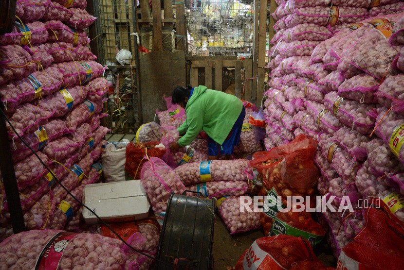 Pekerja memilah  bawang putih di Pasar Induk Kramat Jati, Jakarta, Jumat (6/7). 