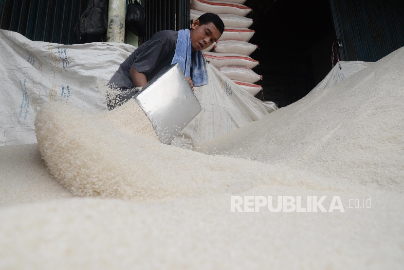 Pekerja memilah beras di Pasar Induk Beras Cipinang, Jakarta Timur, Kamis (13/4).