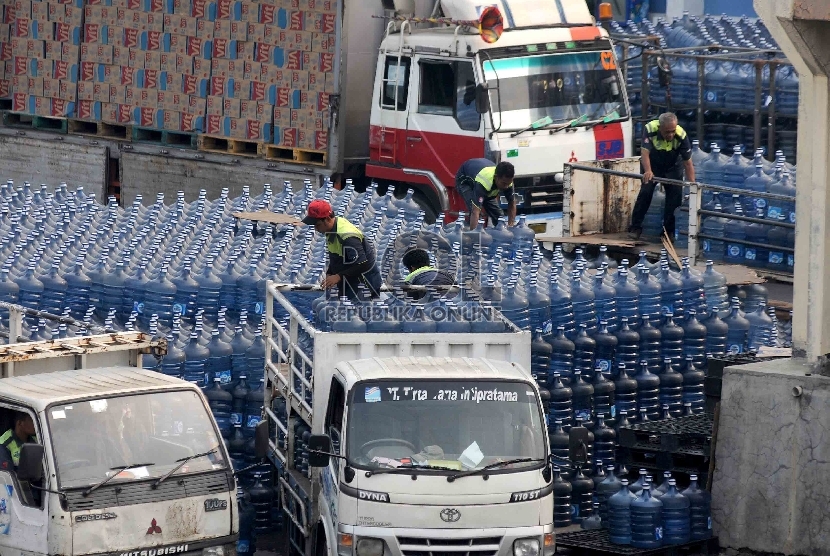  Pekerja memindahkan air kemasa galon ke atas mobil truk d tempat pengisisan air kemasan di Rawa Jati, Jakarta Selatan, Selasa (30/6).