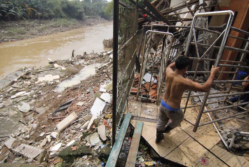 Pekerja memindahkan barang dari pabrik tahu yang rusak akibat longsor di daerah Bekasi Jaya, Jawa Barat, Kamis (27/2). 