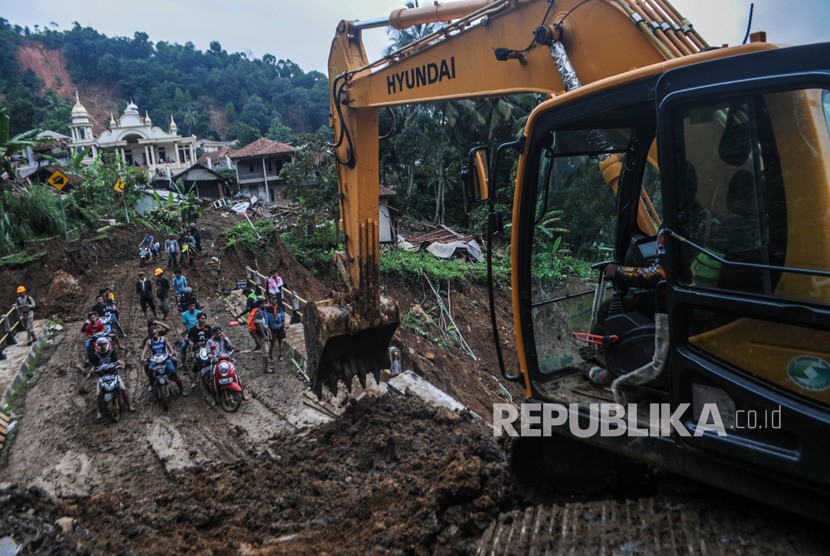 Pengungsi Korban Banjir Lebak Rebutan Bantal dari Relawan. Pekerja memindahkan material lumpur sisa longsor dari jalan di Kampung Cinyiru, Lebak, Banten, Kamis (9/1/2020).