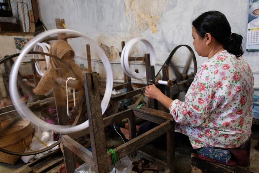 Pekerja memintal benang bahan sarung di industri sarung tenun Gloyor cap Botol Terbang kelurahan Potrobangsan, Kota Magelang, Jawa Tengah Kamis (23/5/2019).