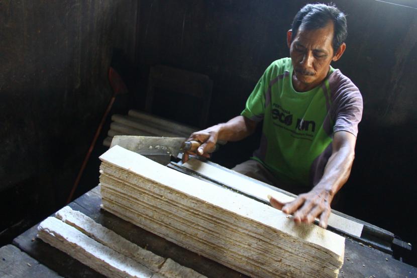 Pekerja memotong tempe untuk dibuat keripik tempe di sentra perajin keripik tempe di Sadang, Ngawi, Jawa Timur, Rabu (2/2/2022). Ketergantungan akan kedelai impor membuat harga tahu tempe naik.