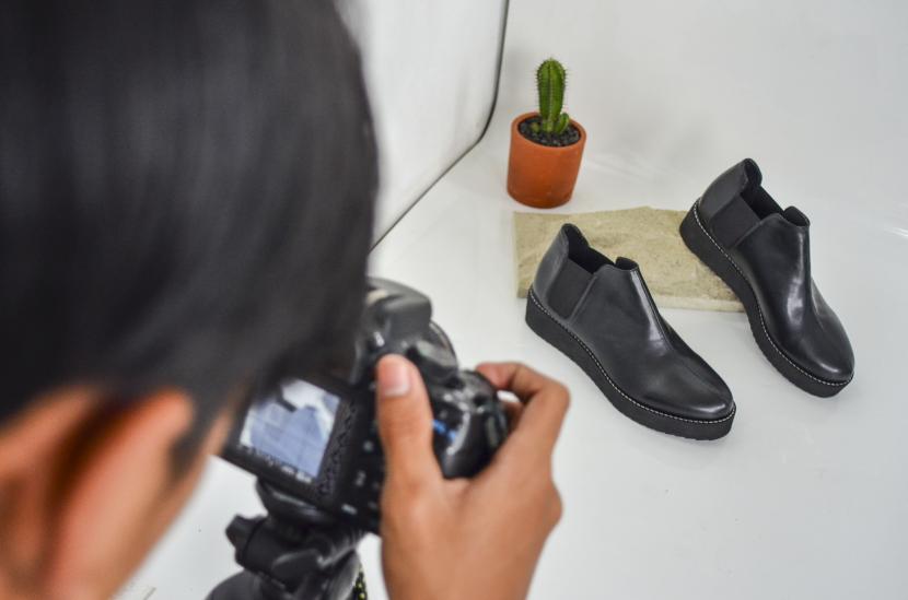 Pekerja memotret produk sepatu Prospero yang akan dipasarkan melalui platform digital di Kota Tasikmalaya, Jawa Barat.