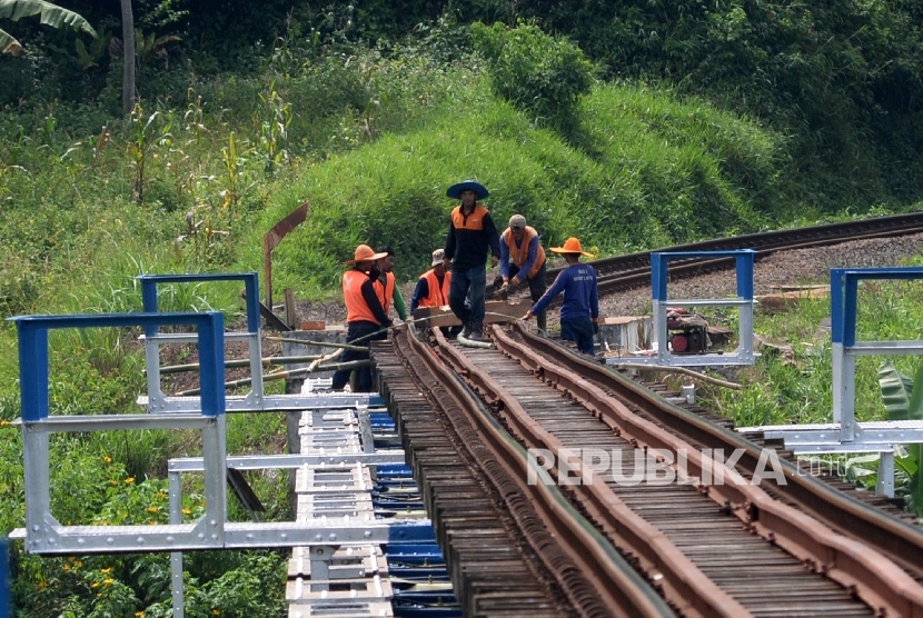 Pekerja memperbaiki bantaran rel kereta api jalur selatan Pulau Jawa. ilustrasi
