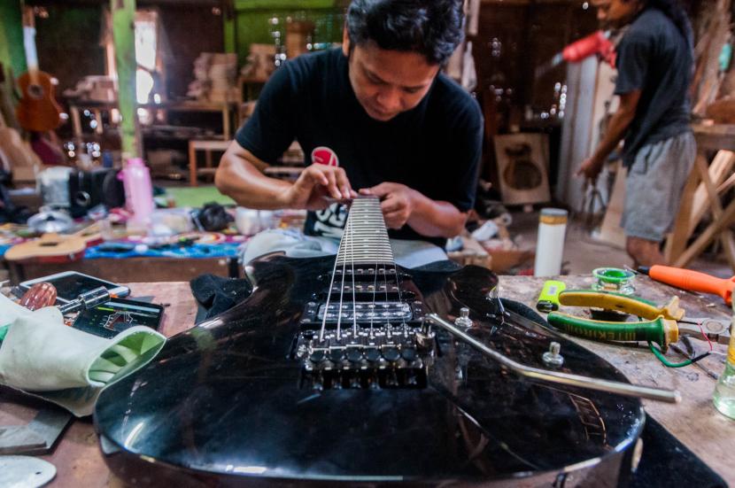 Pekerja memperbaiki gitar pelanggan di UKM Guitars Gore, Lebak, Banten (ilustrasi). Pemkot Serang, Banten,  meyakini penerapan new normal di Kota Serang akan menghidupakan kembali geliat ekonomi di tengah masyarakat yang selama ini terhenti karena corona.