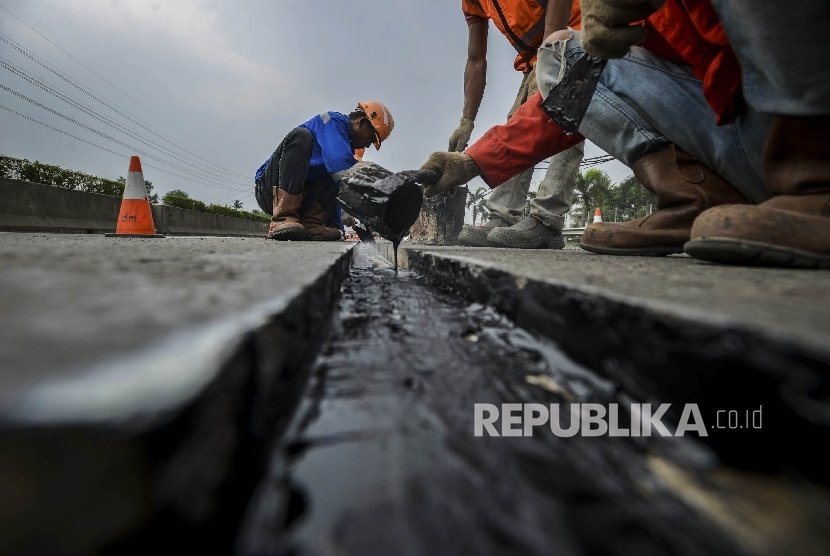  Pekerja memperbaiki jalan yang rusak (ilustrasi)