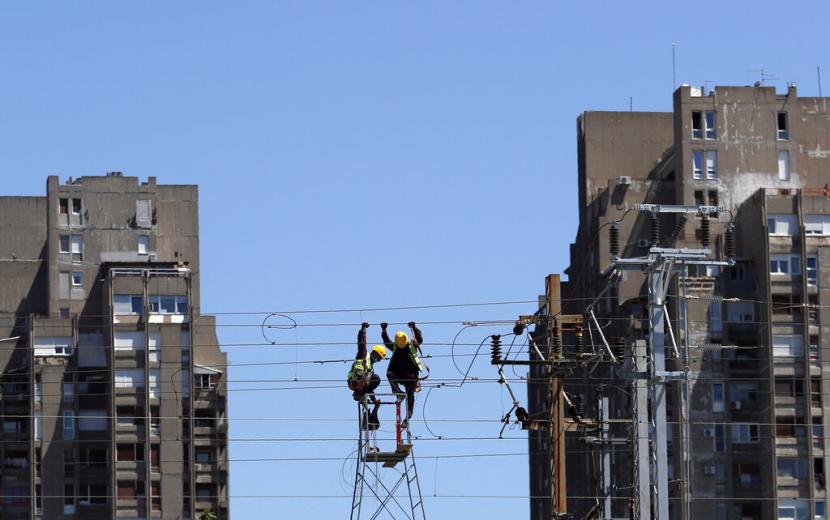 Pekerja memperbaiki kabel listrik jalur kereta di Belgrade, Serbia, Jumat (22/5). Prospek ekonomi negara maju tahun ini telah suram lagi dalam sebulan terakhir akibat pandemi Covid-19 yang telah bergulir dari Asia ke Amerika, menurut survei Reuters. 