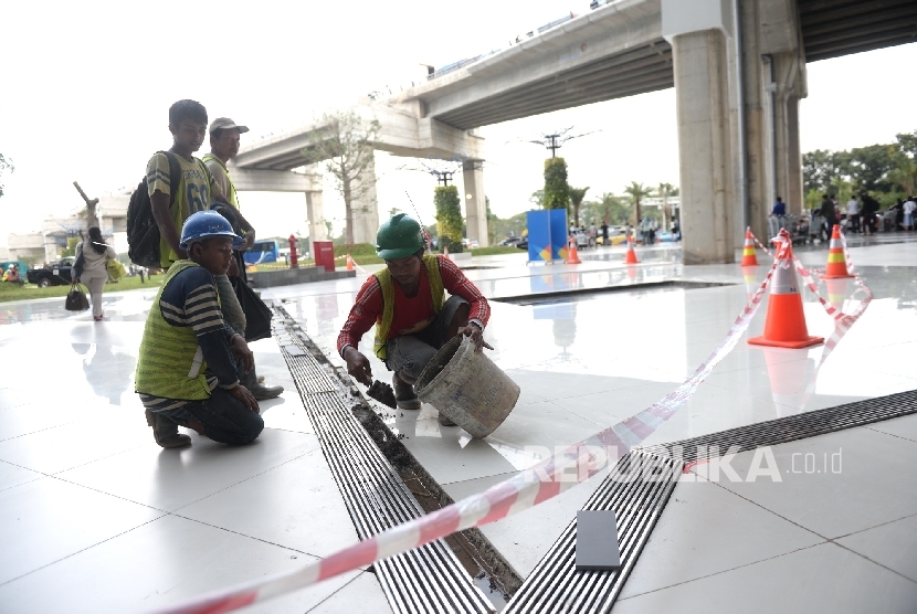 Pekerja memperbaiki lantai halaman Terminal 3 Ultimate pascabanjir, Bandara Soekarno-Hatta, Banten, Senin (15/8). (Republika/ Wihdan)