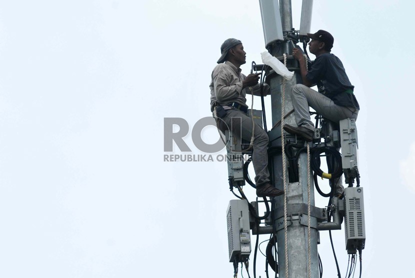  Pekerja memperbaiki menara pemancar telekomunikasi di Jakarta, Selasa (12/8). 
