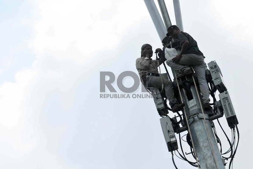  Pekerja memperbaiki menara pemancar telekomunikasi. ilustrasi