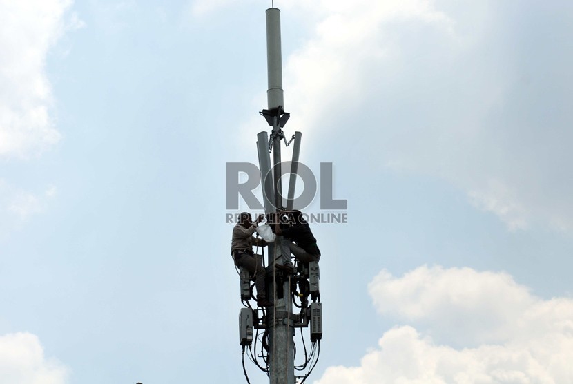  Pekerja memperbaiki menara pemancar telekomunikasi di Jakarta, Selasa (12/8). 