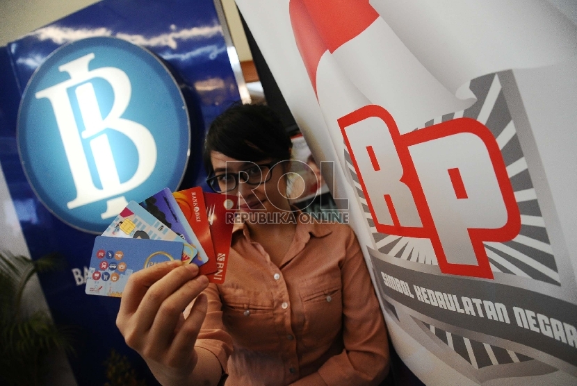 Pekerja memperlihatkan kartu e-money berlogo Gerakan Nasional Non Tunai (GNNT) 'Cinta Non-Tunai, Cinta Rupiah' di pusat perbelanjaan, Jakarta, Kamis (19/11).  (Republika/Tahta Aidilla)