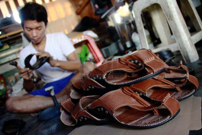 Pekerja memproduksi sepatu dan sandal kulit di bengkel rumahan Sentra Kerajinan Kulit Tanggulangin, Sidoarjo, Jawa Timur, Jumat (11/7).(Republika/ Yasin Habibi).