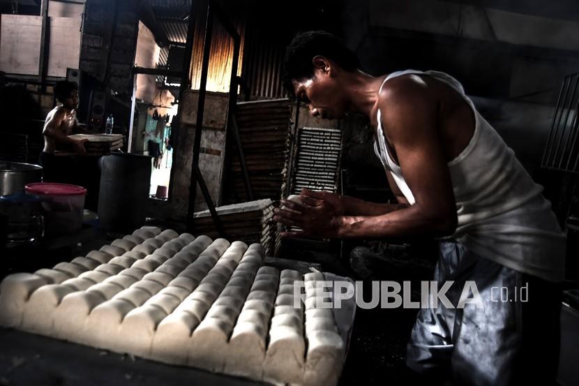 Pekerja memproduksi tahu di lokasi industri rumahan di Jakarta, Kamis (22/10). Otoritas Jasa Keuangan (OJK) mengungkapkan manfaat restrukturisasi bagi perbankan.
