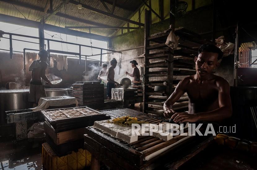 Pekerja memproduksi tahu di Rangkasbitung, Lebak, Banten, Sabtu (19/2/2022). Pengusaha industri rumahan pembuatan tahu di daerah tersebut mengaku terancam tutup karena omzetnya dalam sebulan terakhir menurun sekitar 80 persen akibat harga kedelai melonjak dari sebelumnya Rp300 ribu per karung ukuran 50 kg menjadi Rp570 ribu per karung. 