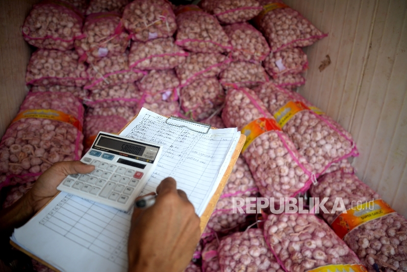  Pekerja menadata bawang putih saat dilaksanakananya operasi pasar komoditas bawang putih di Pasar Senen, Jakarta, Kamis (1/6). 