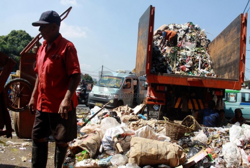  Pekerja menaikkan sampah ke dalam truk sampah di Jatinegara, Jakarta Timur, Selasa (1/7). (Republika/ Yasin Habibi).