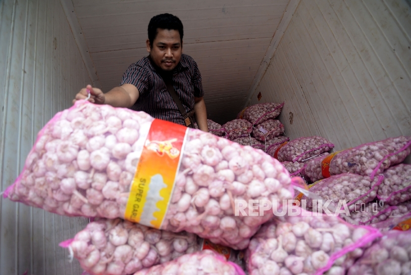  Pekerja menata bawang putih saat dilaksanakananya operasi pasar komoditas bawang putih di Pasar Senen, Jakarta, Kamis (1/6). 