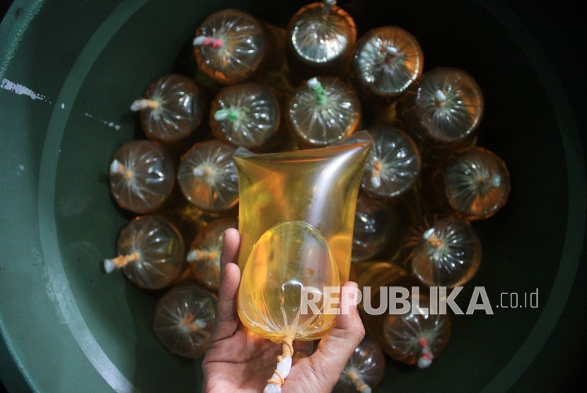 Pekerja menata minyak goreng curah yang sudah dikemas kantong plastik di salah satu agen penjualan minyak goreng curah di Surabaya, Jawa Timur, Rabu (5/1/2022). Pemerintah menetapkan, penyediaan minyak goreng seharga Rp 14 ribu per liter berlaku secara nasional.