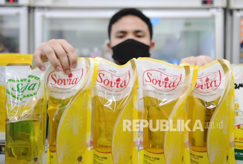 Pekerja menata minyak goreng kemasan yang dijual di salah satu minimarket di Jakarta, Rabu (19/1/2022). Menteri Perdagangan Muhammad Lutfi menetapkan kebijakan satu harga minyak goreng kemasan yakni Rp14.000 per liter yang dijual di minimarket mulai Rabu (19/1/2022).