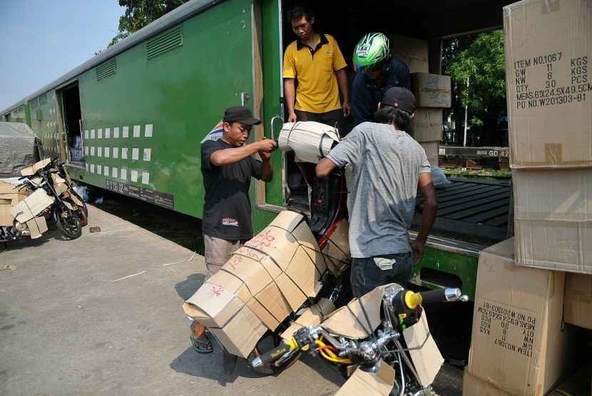 Pekerja menata sepeda motor yang akan dikirim melalui jasa pengiriman kereta api.