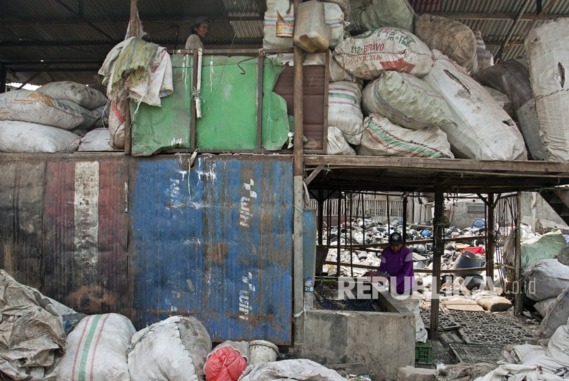 Pekerja mencacah sampah plastik