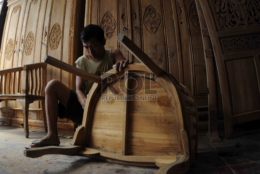 Pekerja mengamplas kursi kayu di tempat pembuatan furnitur dikawasan Manggarai, Jakarta, Senin (3/8).