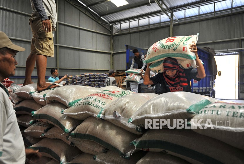 Pekerja mengangkat karung berisi beras kualitas premium di Gudang Bulog Sub Divisi Regional Serang, Banten, Jumat (2/8/2019).