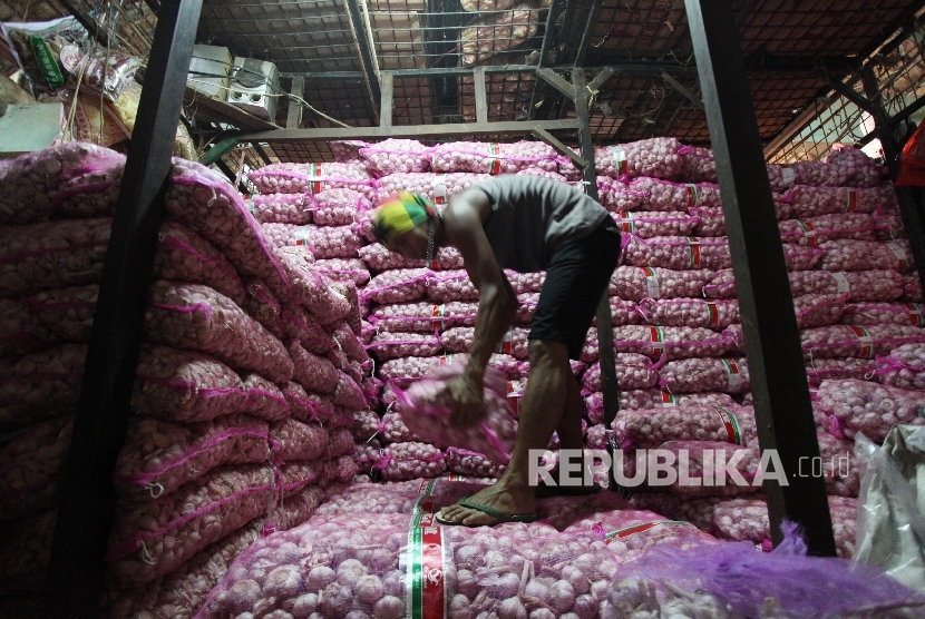 Pekerja mengangkut bawang putih di Pasar Induk Kramat Jati, Jakarta, Rabu (17/5).