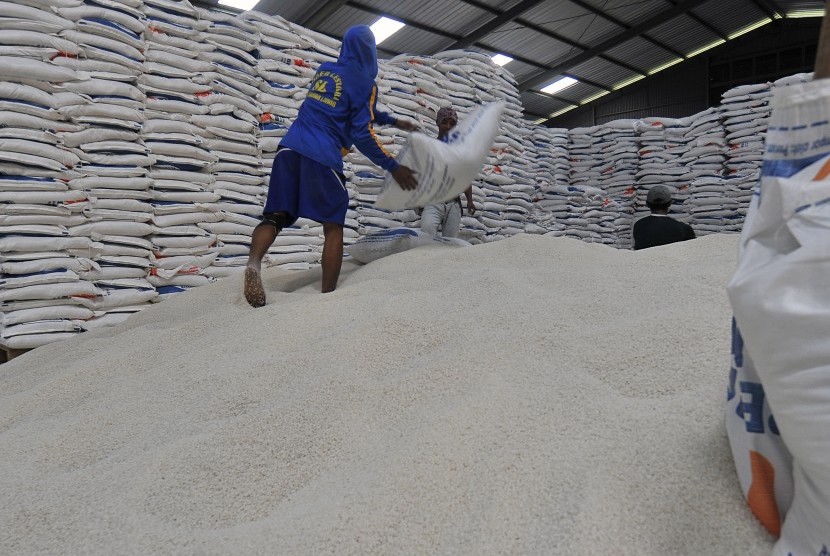 Pekerja mengangkut karung berisi beras dari gudang Perum Bulog untuk dijual ke pasar di Serang, Banten, Sabtu (8/12/2018).