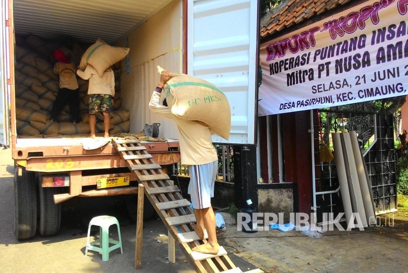 Pekerja mengangkut karung biji kopi (green been) asal Gunung Puntang ke dalam truk kontainer untuk diekspor ke Maroko, Afrika Utara, di Desa Pasirhuni, Kecamatan Cimaung, Kabupaten Bandung, Rabu (22/6). (Republika/Umar Mukhtar)