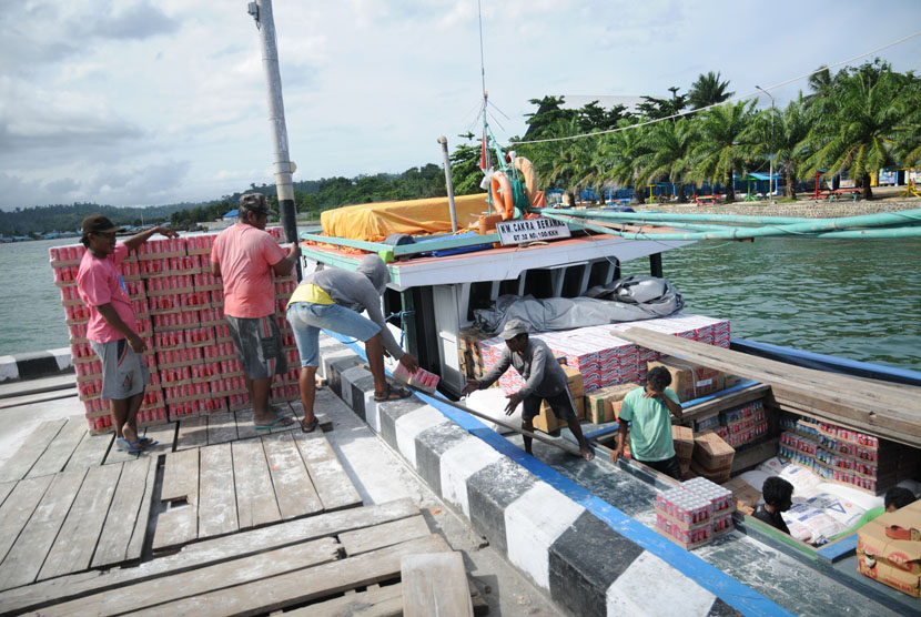 Pekerja mengangkut logistik yang akan dikirim ke wilayah Wasior menggunakan kapal di dermaga TNI AL, Manokwari, Papua Barat, Rabu (3/12).