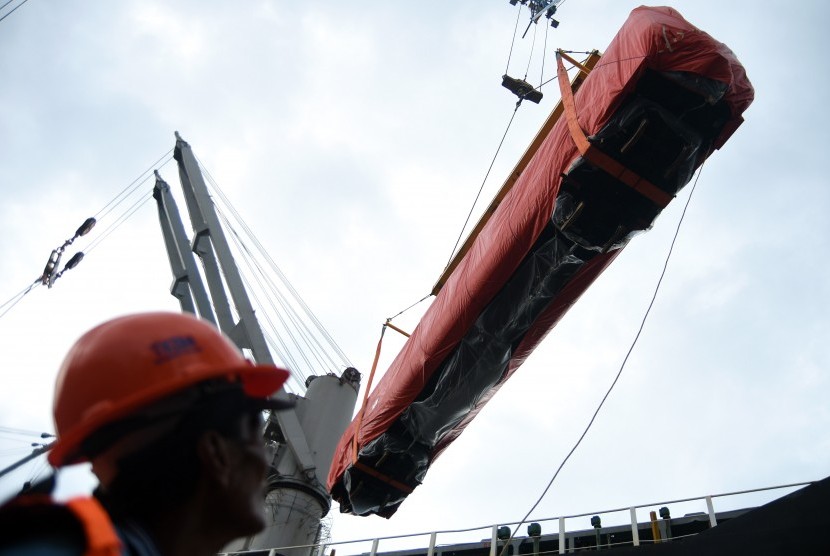 Pekerja mengawasi proses pemindahan gerbong kereta api dari truk pengangkut ke kapal kargo Seiyo Spring di Terminal Jamrud Utara Pelabuhan Tanjung Perak, Surabaya, Jawa Timur, Rabu (30/3).