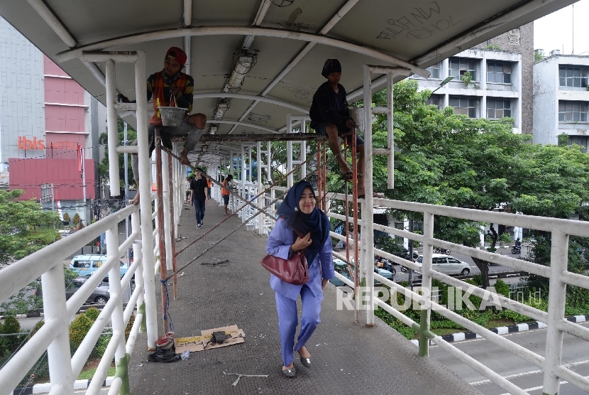 Pekerja mengecat jembatan penyeberangan orang (JPO). (Ilustrasi)