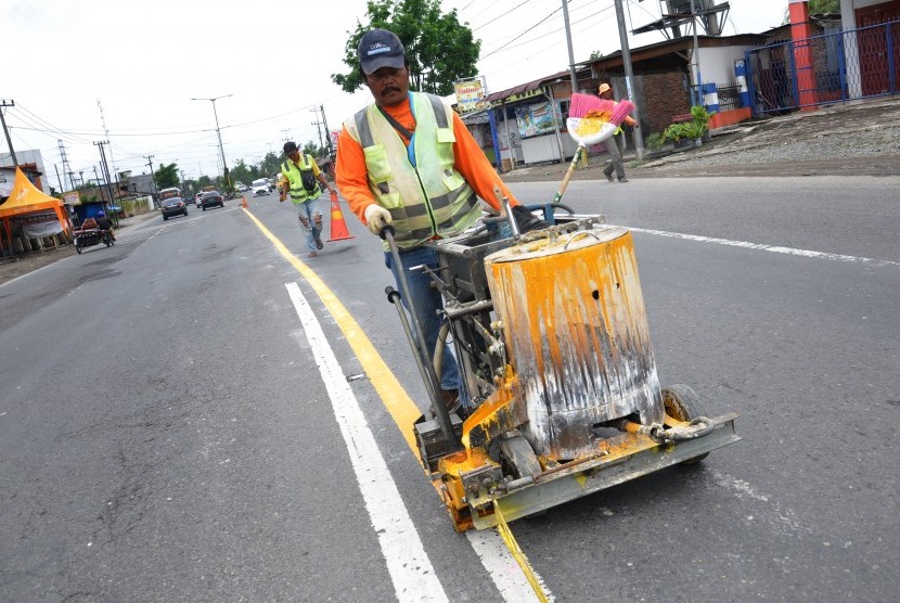 Pekerja mengecat marka jalan di Jalan Lintas Sumatera (Jalinsum) Tanjung Morawa, Kabupaten Deliserdang, Sumatera Utara, Kamis (16/5/2019). 
