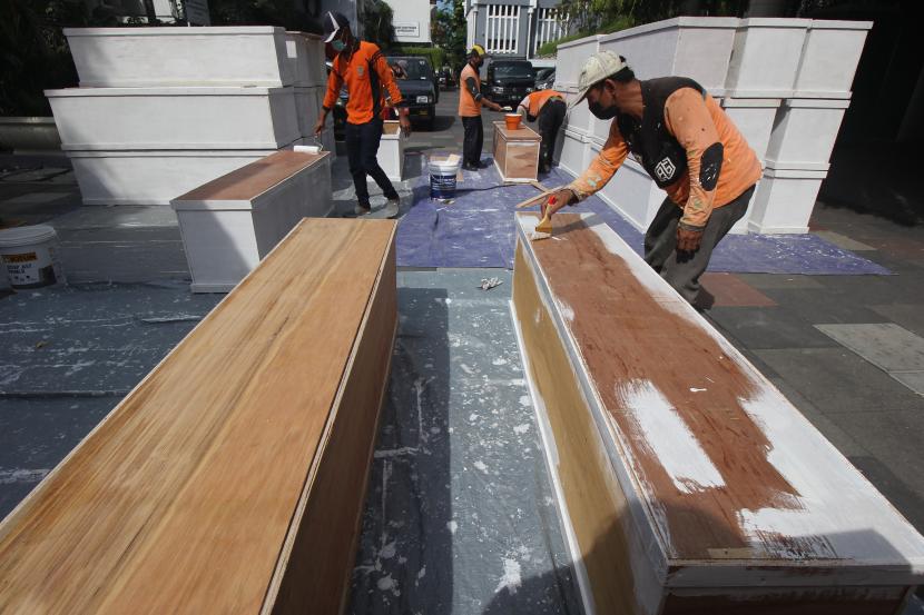 Pekerja mengecat peti jenazah di halaman belakang Balai Kota Surabaya, Jawa Timur, Jumat (2/7/2021). Pemkot Surabaya membuat peti jenazah bagi warga yang membutuhkannya sebagai upaya untuk mengantisipasi antrean pemulasaraan jenazah dengan protokol COVID-19.
