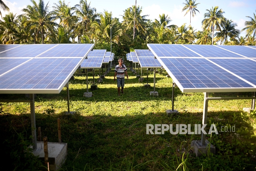 Pekerja mengecekan terhadap panel surya di pembangkit Listrik Tenag Surya di Pulau Minagas, Sulut, Senin (18/4).