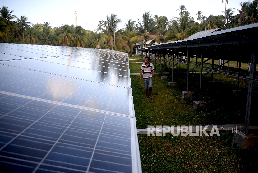 Pekerja mengecekan terhadap panel surya di pembangkit Listrik Tenag Surya di Pulau Minagas, Sulut, Senin (18/4).