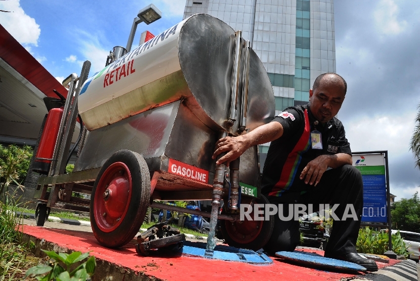 Pekerja mengeluarkan bensin usai melakukan pengukuran liter di SPBU, Jakarta, Rabu (17/2).