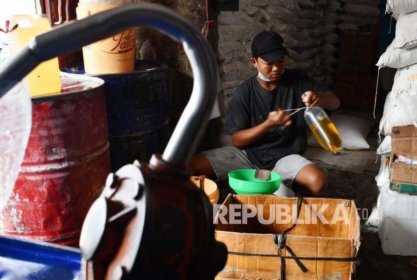 Pekerja mengemas minyak goreng curah menggunakan plastik ukuran satu kilogram di sebuah toko tradisional (ilustrasi). Harga minyak goreng di Kendari, Sulawesi Tenggara, masih di atas Rp 14 ribu per liter.