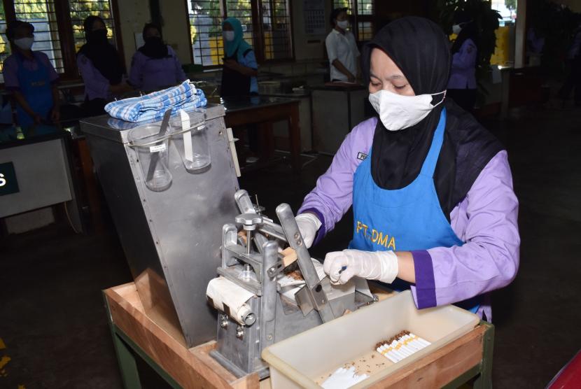 Pekerja mengenakan sarung tangan dan masker guna pencegahan penularan COVID-19 melinting rokok sigaret kretek tangan di pabrik rokok PT Digjaya Mulia Abadi (DMA) mitra PT HM Sampoerna, Kabupaten Madiun, Jawa Timur, Selasa (16/6/2020). Pabrik rokok yang mempekerjakan 890 orang pekerja tersebut beroperasi lagi setelah diliburkan selama sepekan menyusul adanya seorang pekerja yang dinyatakan positif COVID-19.
