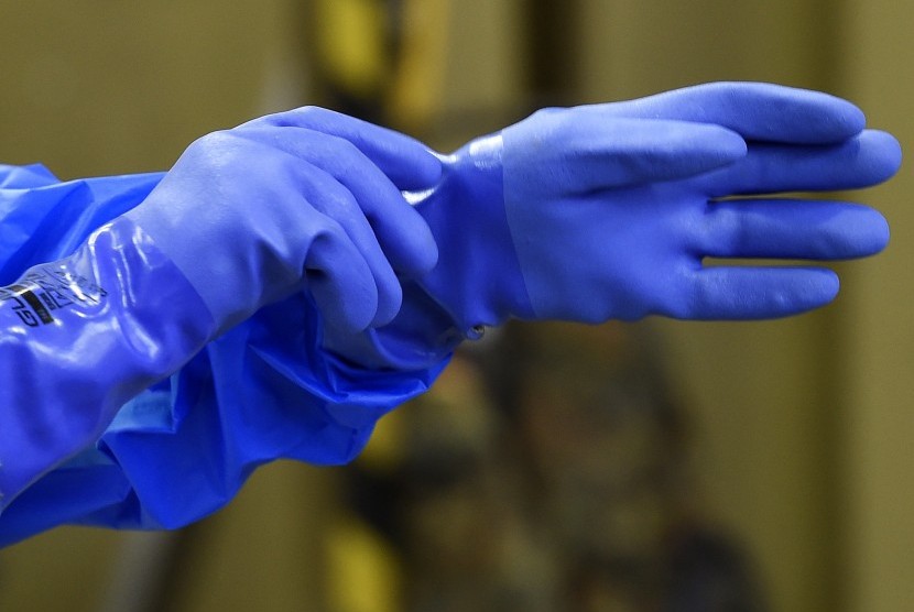 Pekerja mengenakan sarung tangan karet saat pelatihan penanganan ebola oleh tentara Jerman.