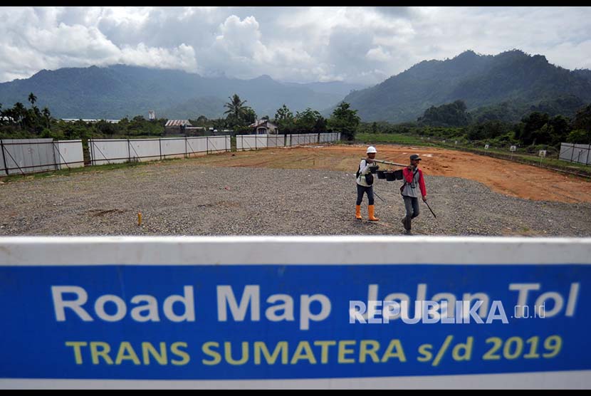 Pekerja mengerjakan pemasangan patok BM (benchmark) untuk acuan koordinat pada proyek Tol Sumbar-Riau di Jalan Bypass KM 25, Padangpariaman, Sumatra Barat, Selasa (3/4).