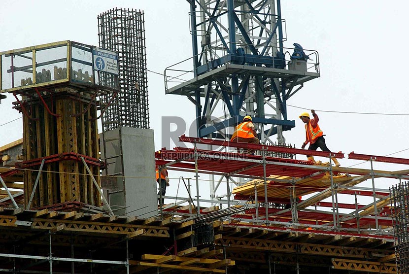 Pekerja mengerjakan pembangunan gedung bertingkat di Jakarta, Rabu (19/2).
